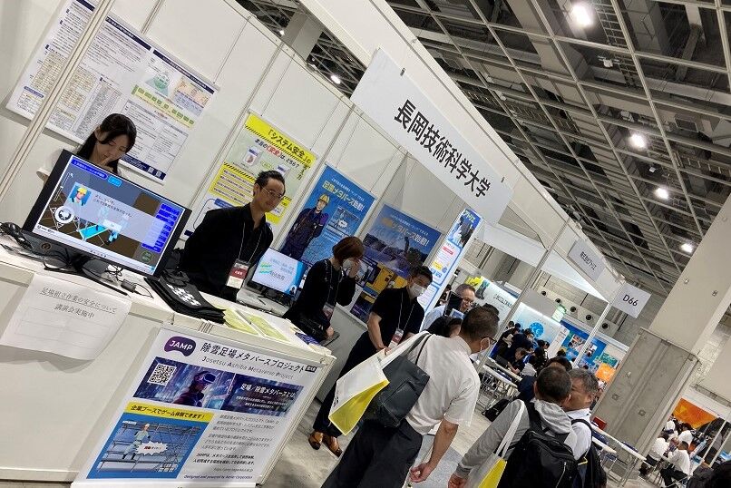 本学教員の説明を受けている来場者